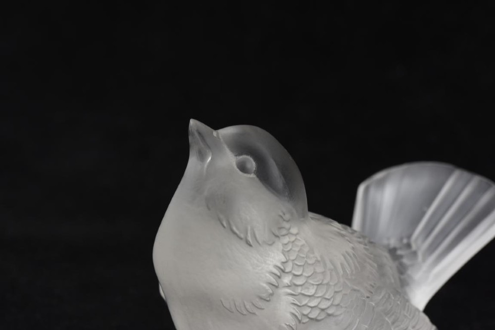 A frosted crystal glass figurine of a small sparrow perched on an integrated base with its head tilted upwards. View III