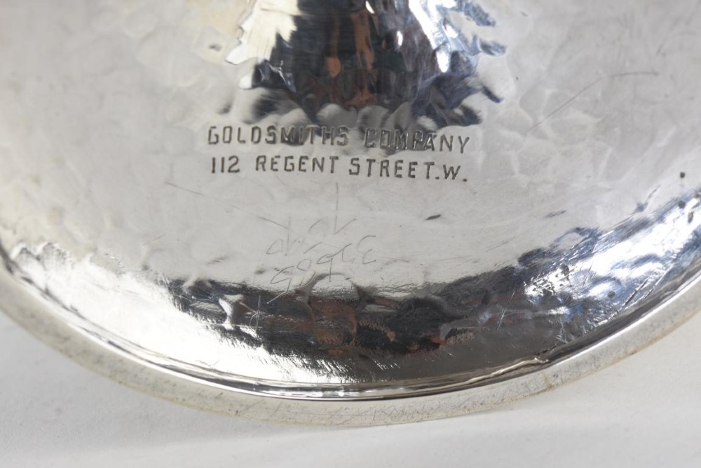 A hand-hammered sterling silver tazza dish supported by three curved legs attached to a round raised base. View V