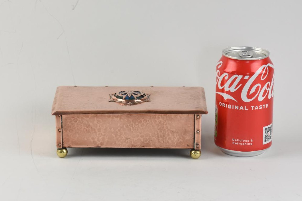 A rectangular hand-hammered copper box featuring brass ball feet, riveted corners, and a central blue enamel cabochon with a pierced butterfly overlay on the lid. View VIII