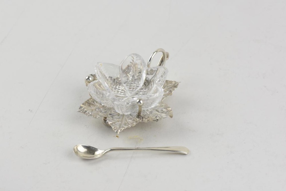 A pair of Aesthetic Period silver salt cellars with leaf-shaped bases, clear glass lotus liners, matching silver spoons, housed in a fitted velvet presentation case. View II