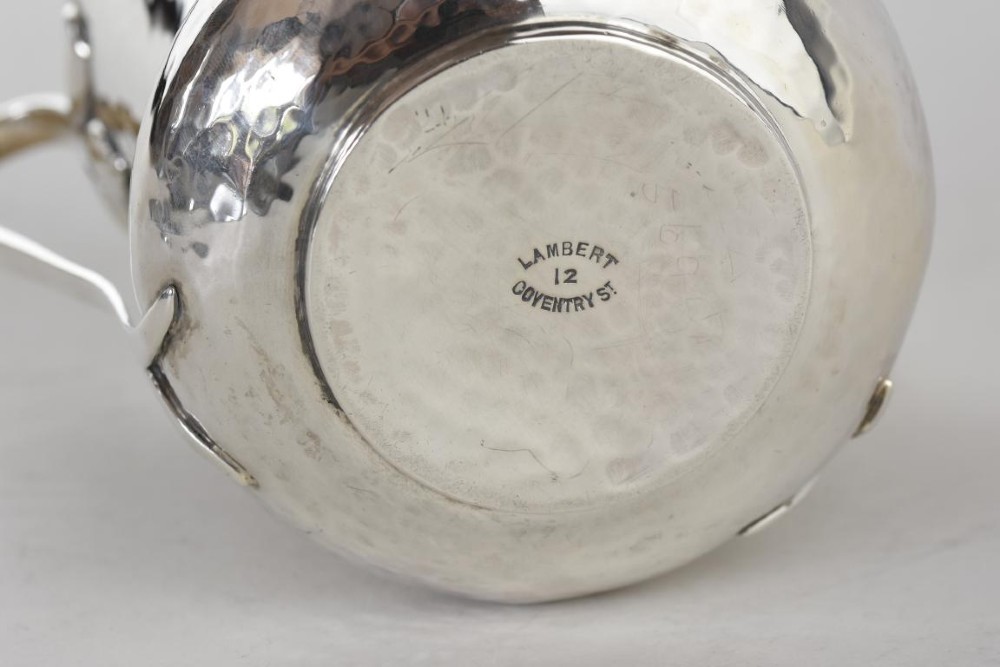 A hand-hammered silver three-handled tyg cup with a planished finish and stylized handle mounts. View III