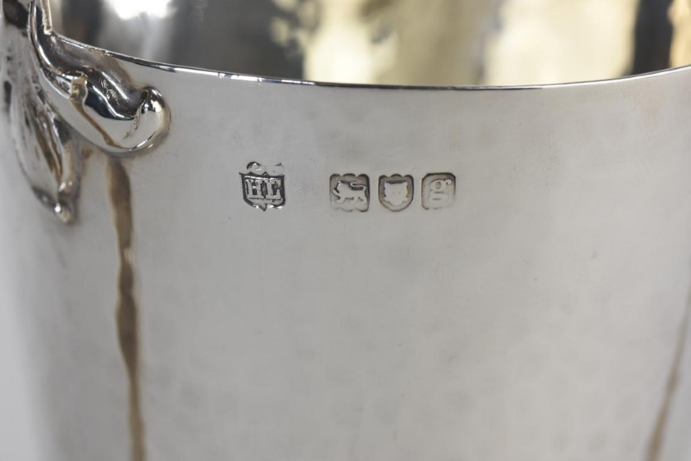 A hand-hammered silver three-handled tyg cup with a planished finish and stylized handle mounts. View IV