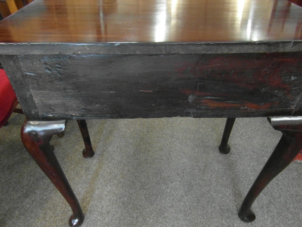 A Georgian dark mahogany lowboy featuring three drawers with brass handles, a shaped lower apron, and cabriole legs ending in pad feet. View III