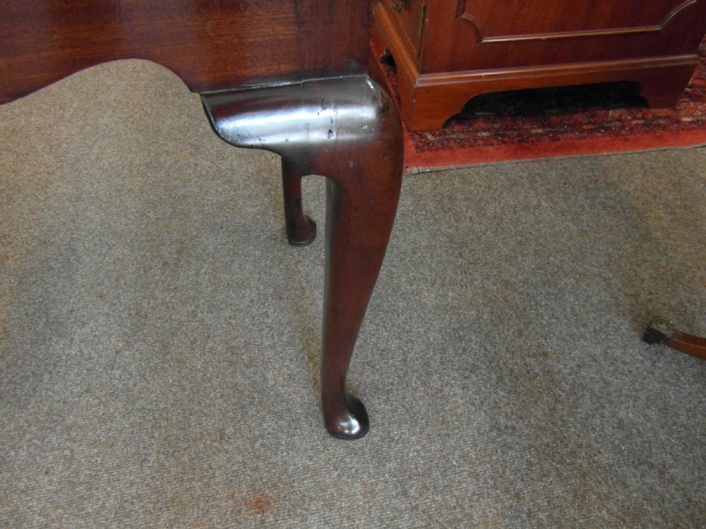 A Georgian dark mahogany lowboy featuring three drawers with brass handles, a shaped lower apron, and cabriole legs ending in pad feet. View IV