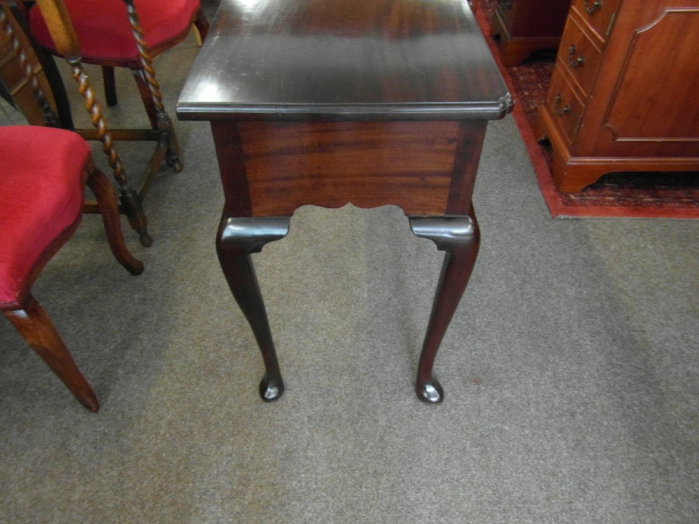 A Georgian dark mahogany lowboy featuring three drawers with brass handles, a shaped lower apron, and cabriole legs ending in pad feet. View VI