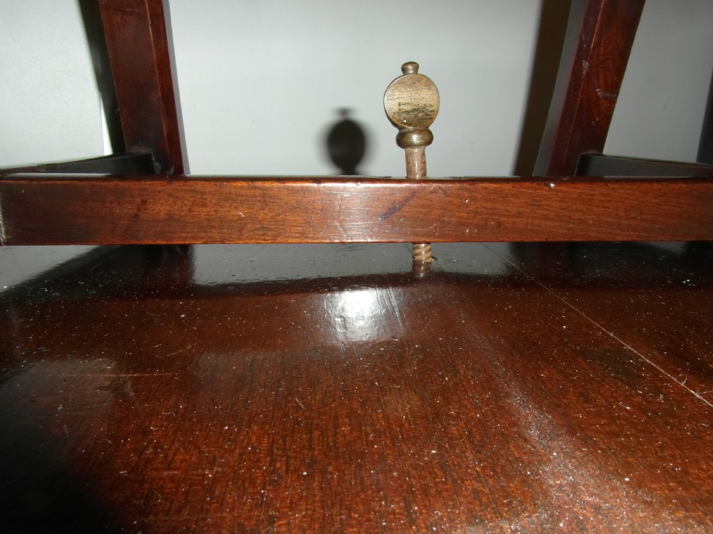 An antique Georgian mahogany childs high chair featuring a carved pierced splat back, wooden safety bar, upholstered seat, and integrated footrest on a wooden stand. View VIII