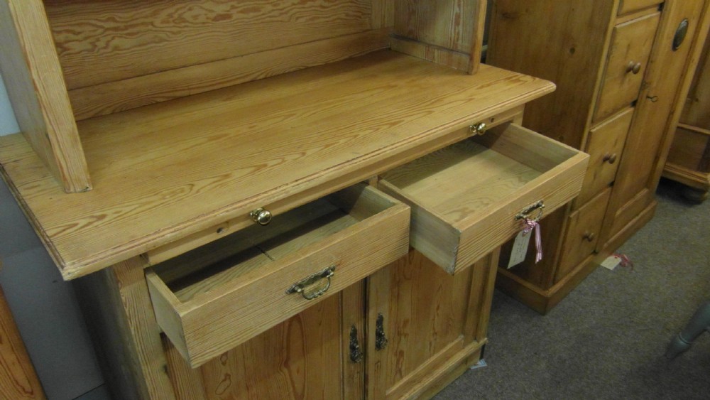 A Victorian pine kitchen dresser featuring an upper two-door cabinet with pleated fabric panels over a base unit with two drawers and two cupboard doors. View III