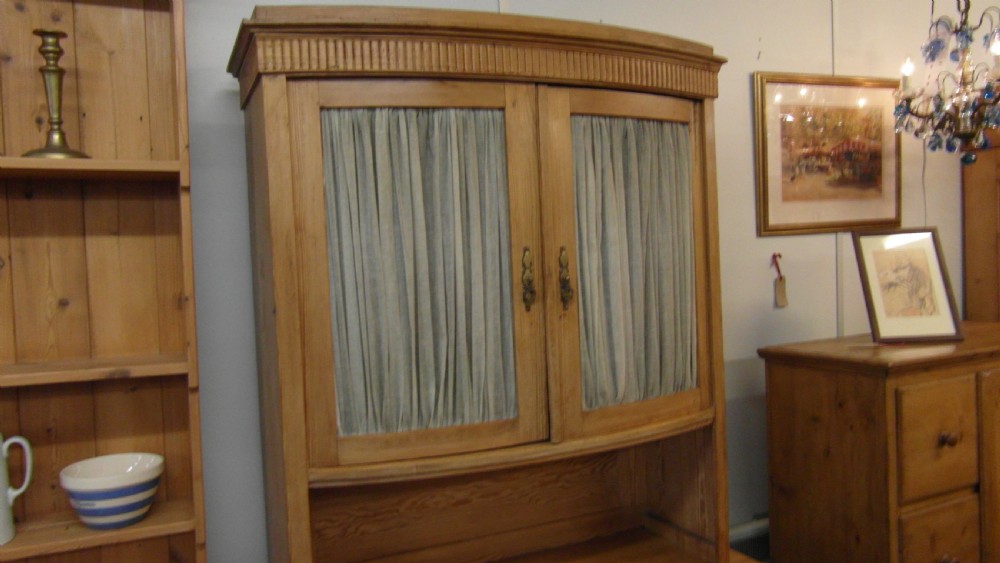 A Victorian pine kitchen dresser featuring an upper two-door cabinet with pleated fabric panels over a base unit with two drawers and two cupboard doors. View IV