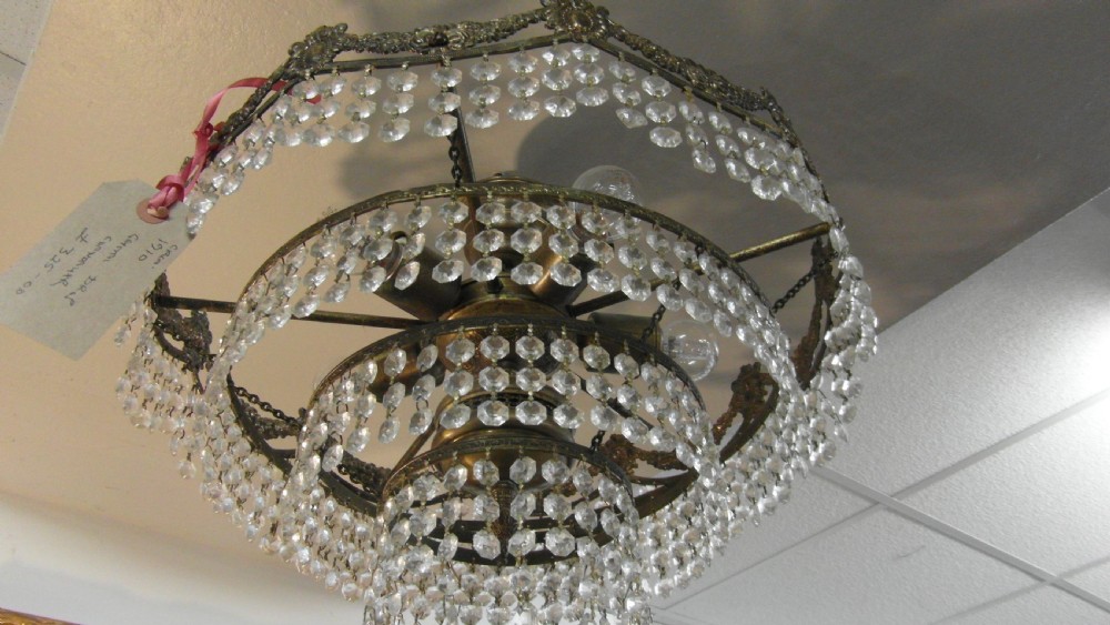 A tiered Art Deco cut glass chandelier featuring strings of crystal beads suspended from an ornate dark metal gallery with decorative scrollwork. View II