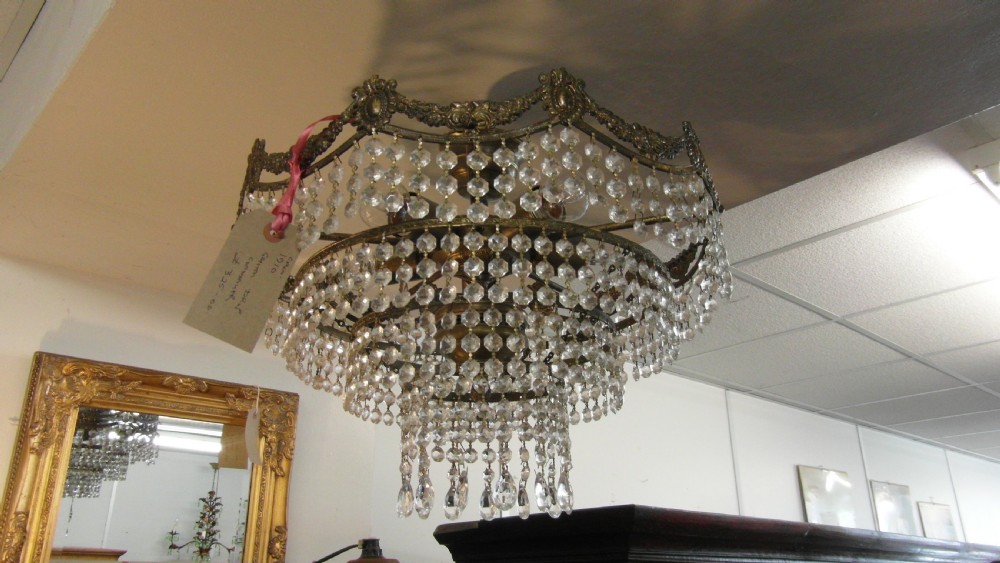 A tiered Art Deco cut glass chandelier featuring strings of crystal beads suspended from an ornate dark metal gallery with decorative scrollwork. View III