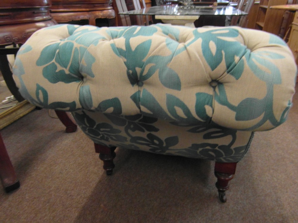 A Victorian upholstered chaise longue featuring deep-buttoned tufting in a teal and cream floral pattern with short turned wooden legs. View V