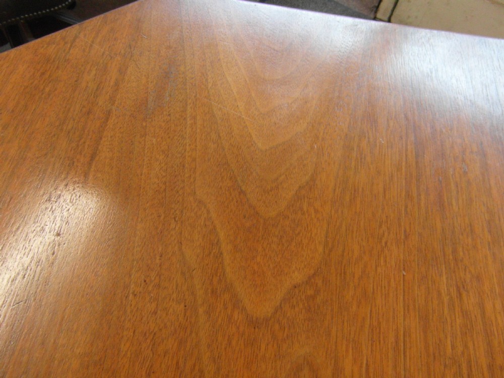 A Victorian octagonal walnut centre table with turned column supports, carved scrolled legs, and porcelain castors. View V