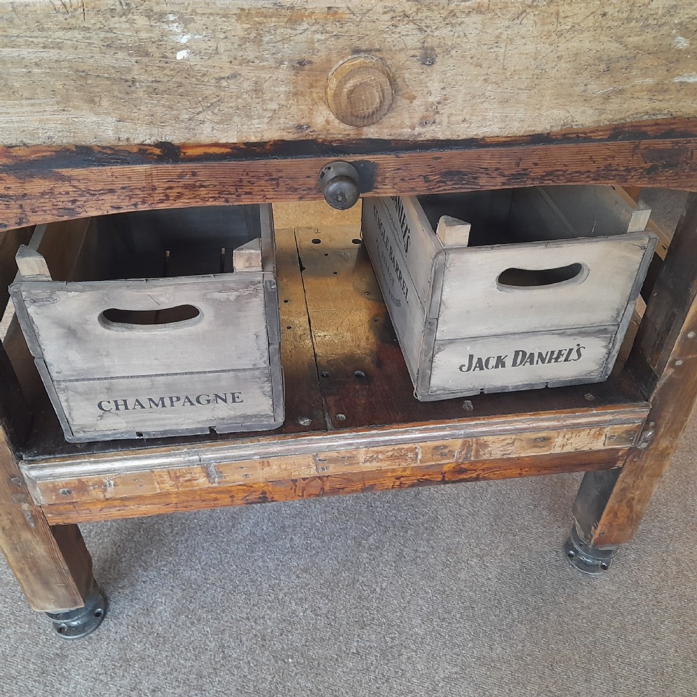 An antique butchers block featuring a thick end-grain timber top reinforced with iron corner brackets on a wooden stand with a lower shelf. View III