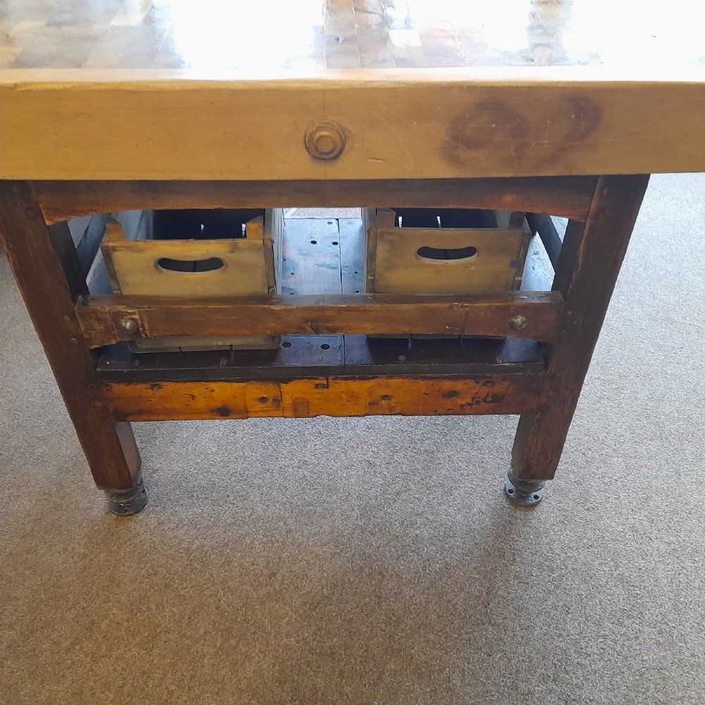 An antique butchers block featuring a thick end-grain timber top reinforced with iron corner brackets on a wooden stand with a lower shelf. View IV