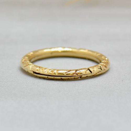 fig 2. An antique 14ct yellow gold circular split ring featuring continuous hand-engraved geometric pattern along its outer edge.