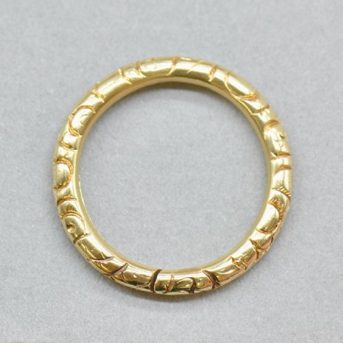 fig 3. An antique 14ct yellow gold circular split ring featuring continuous hand-engraved geometric pattern along its outer edge.
