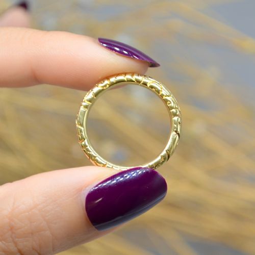 fig 4. An antique 14ct yellow gold circular split ring featuring continuous hand-engraved geometric pattern along its outer edge.