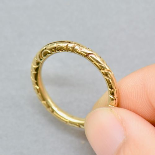fig 5. An antique 14ct yellow gold circular split ring featuring continuous hand-engraved geometric pattern along its outer edge.