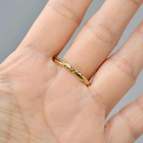 fig 6. An antique 14ct yellow gold circular split ring featuring continuous hand-engraved geometric pattern along its outer edge.