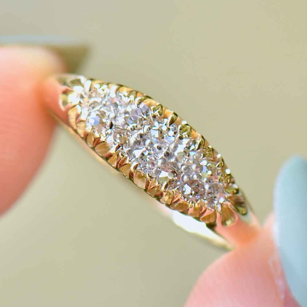 A Victorian gold ring featuring a boat-shaped setting set with two rows of old mine cut diamonds.