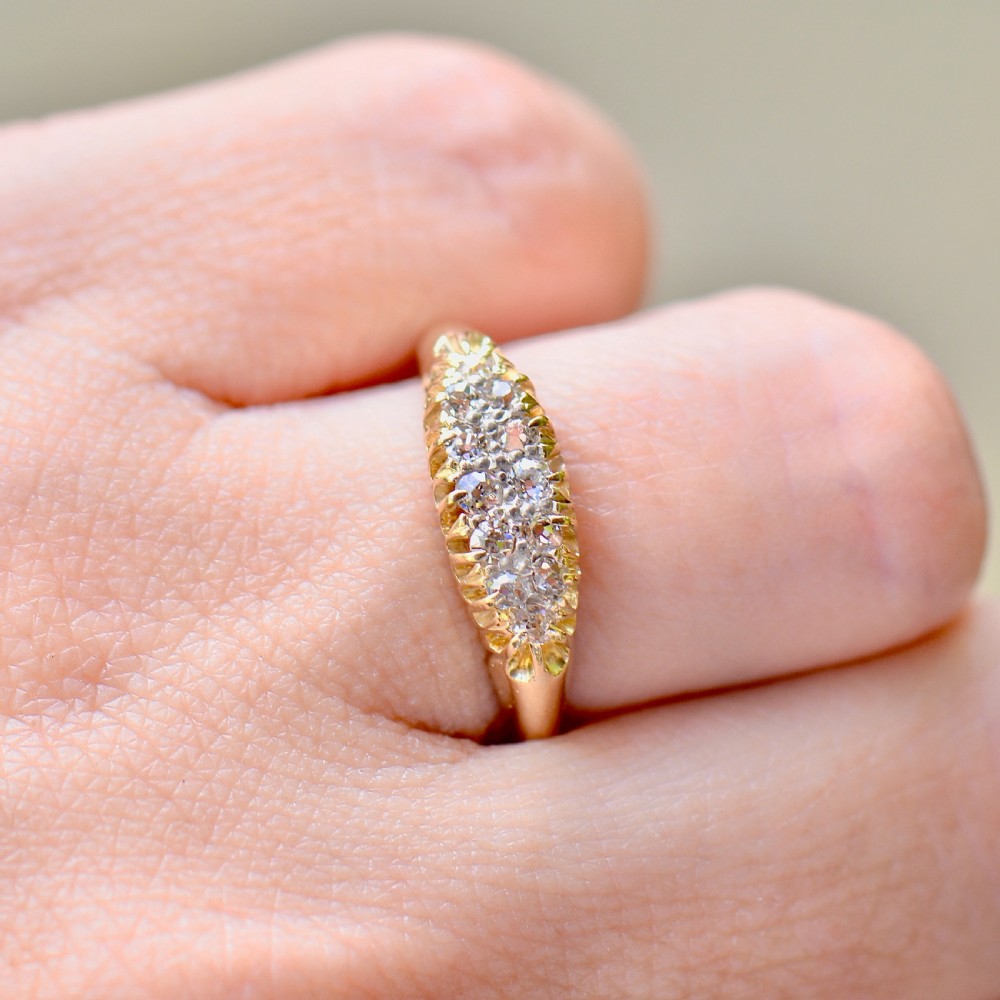A Victorian gold ring featuring a boat-shaped setting set with two rows of old mine cut diamonds. View VIII