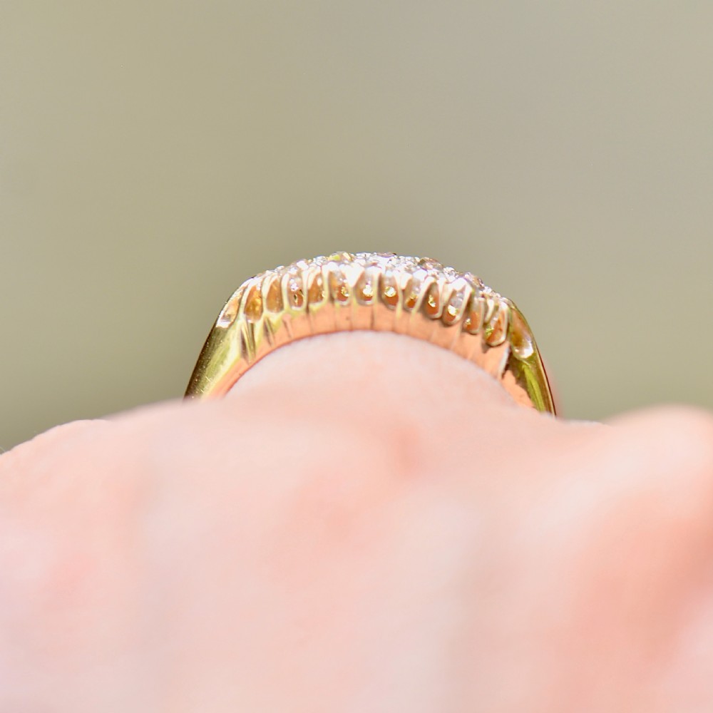 A Victorian gold ring featuring a boat-shaped setting set with two rows of old mine cut diamonds. View IX