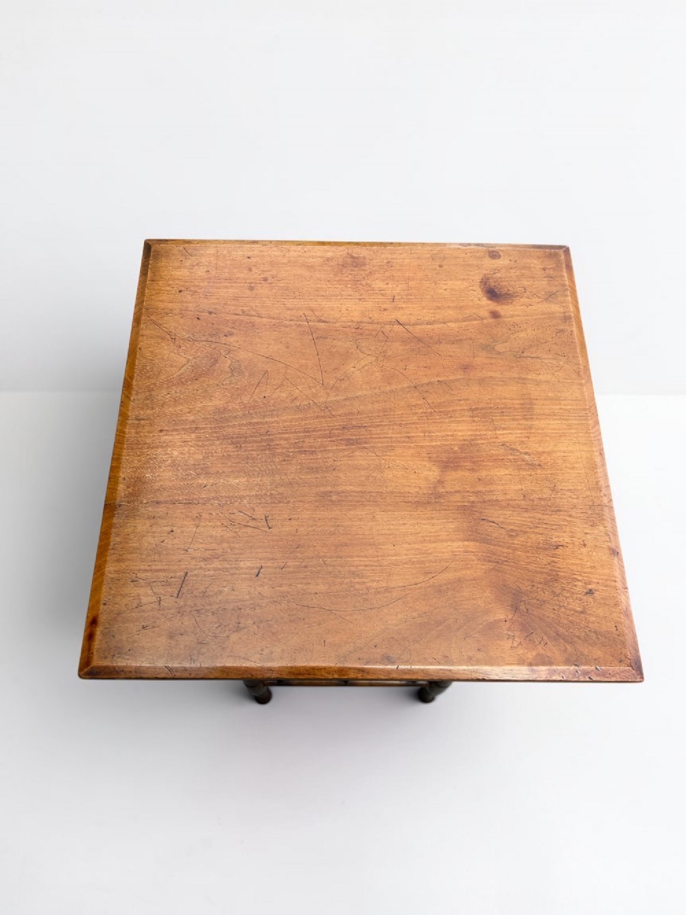 A square walnut side table in the Aesthetic Movement style featuring turned legs with incised rings, an undertier shelf, and spindled lower bracing. View III