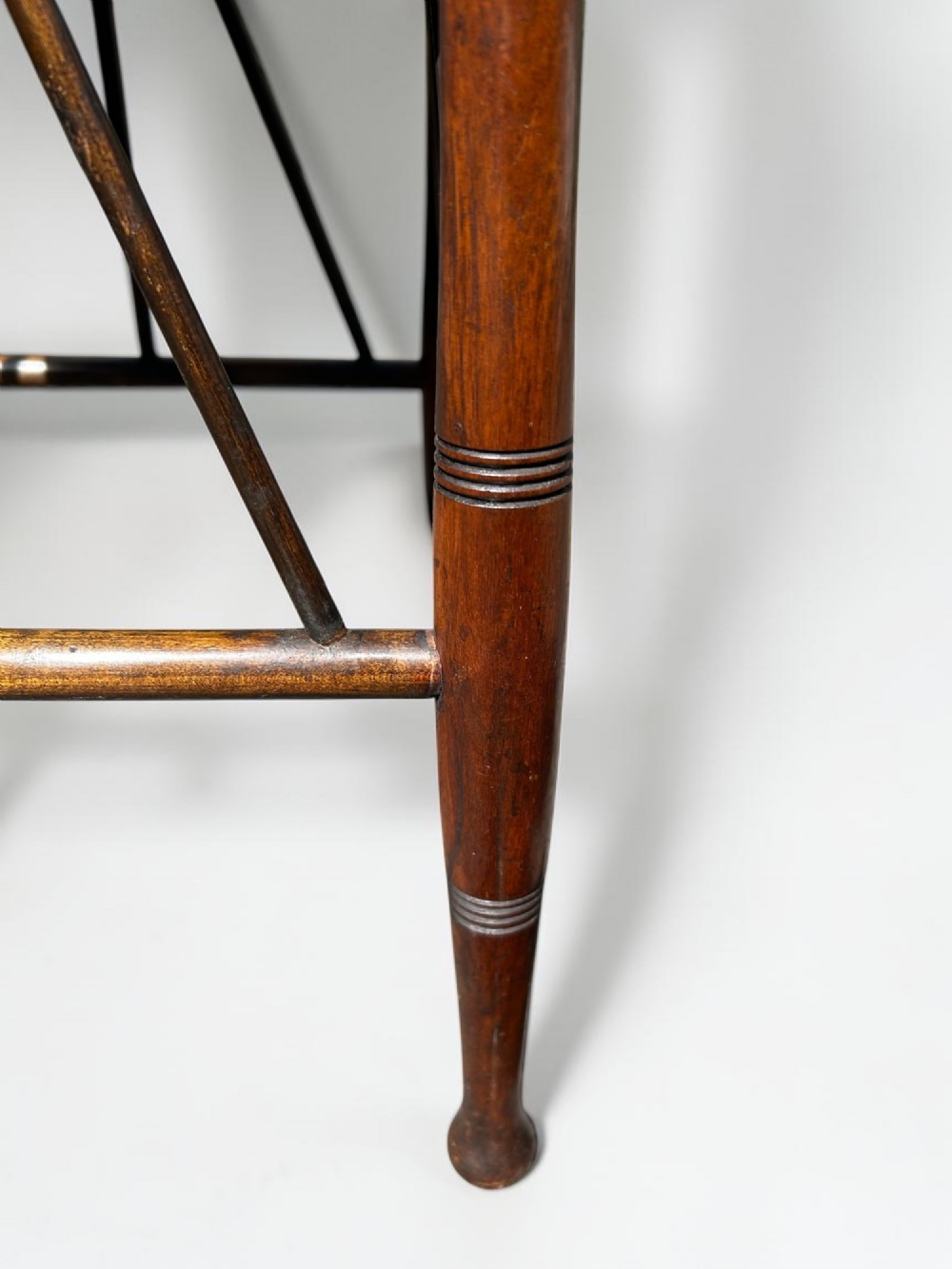 A square walnut side table in the Aesthetic Movement style featuring turned legs with incised rings, an undertier shelf, and spindled lower bracing. View V