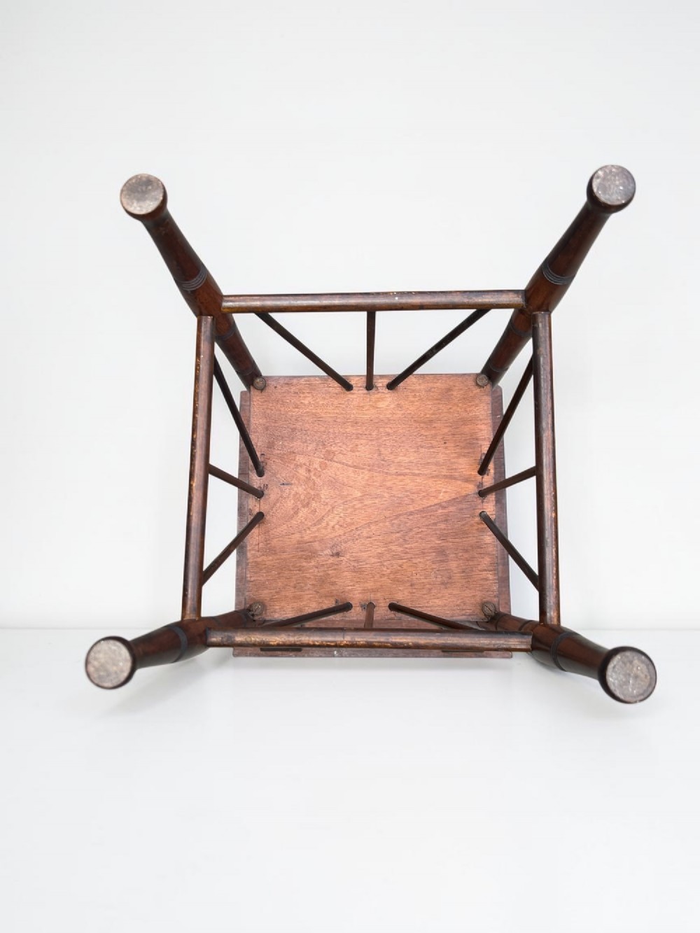 A square walnut side table in the Aesthetic Movement style featuring turned legs with incised rings, an undertier shelf, and spindled lower bracing. View VII
