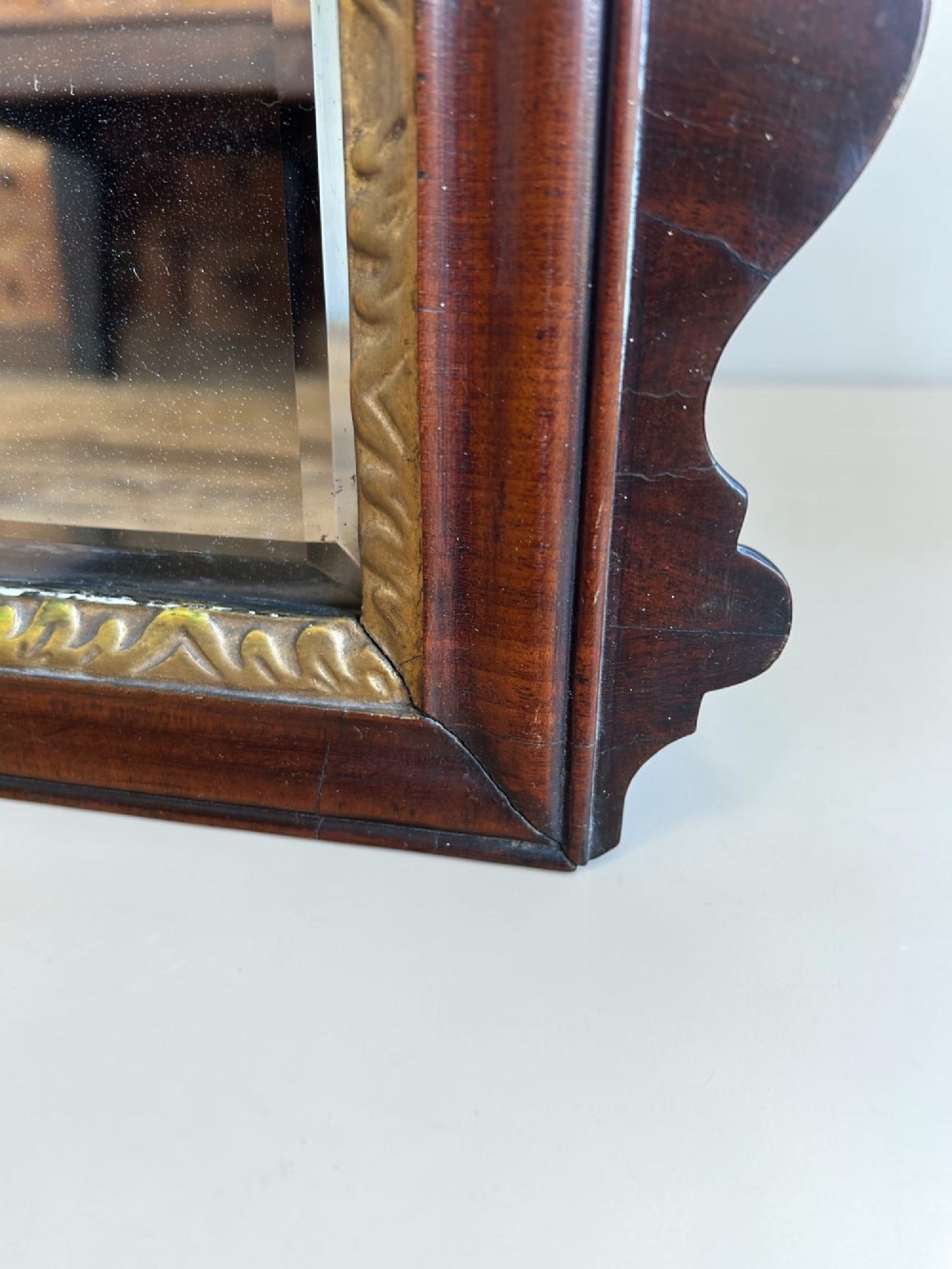 A horizontal George I walnut overmantel mirror featuring three bevelled glass plates, a gilded inner lip, and shaped side wings. View III