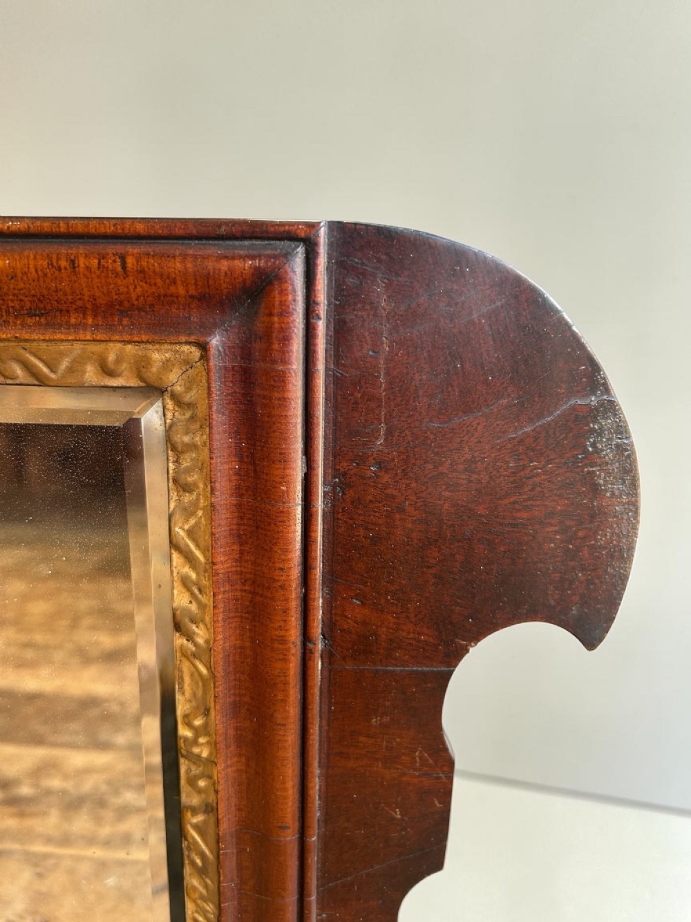 A horizontal George I walnut overmantel mirror featuring three bevelled glass plates, a gilded inner lip, and shaped side wings. View IV