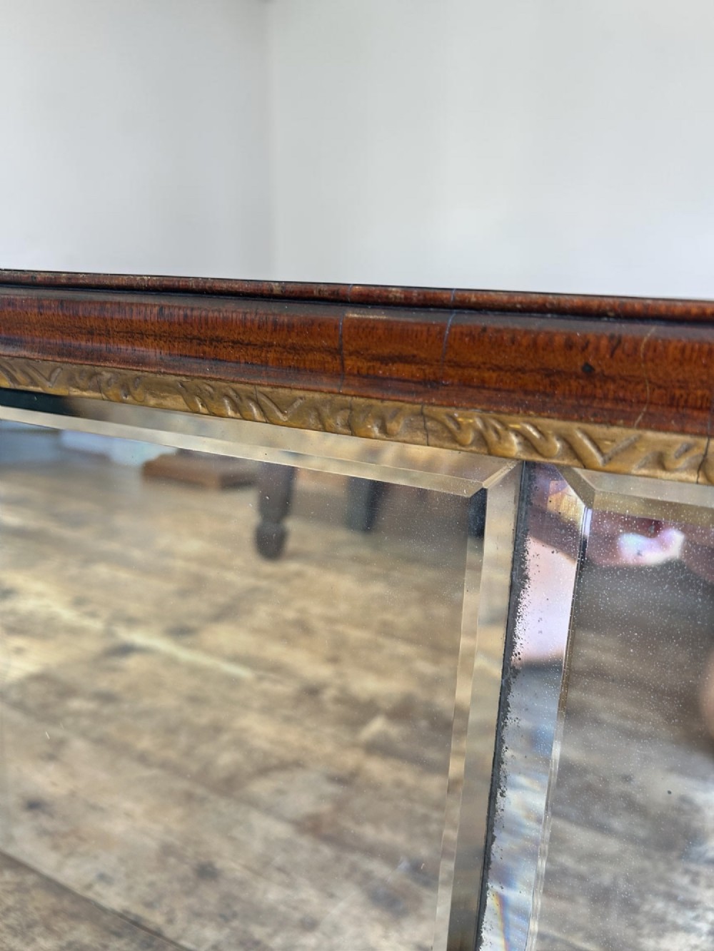A horizontal George I walnut overmantel mirror featuring three bevelled glass plates, a gilded inner lip, and shaped side wings. View V