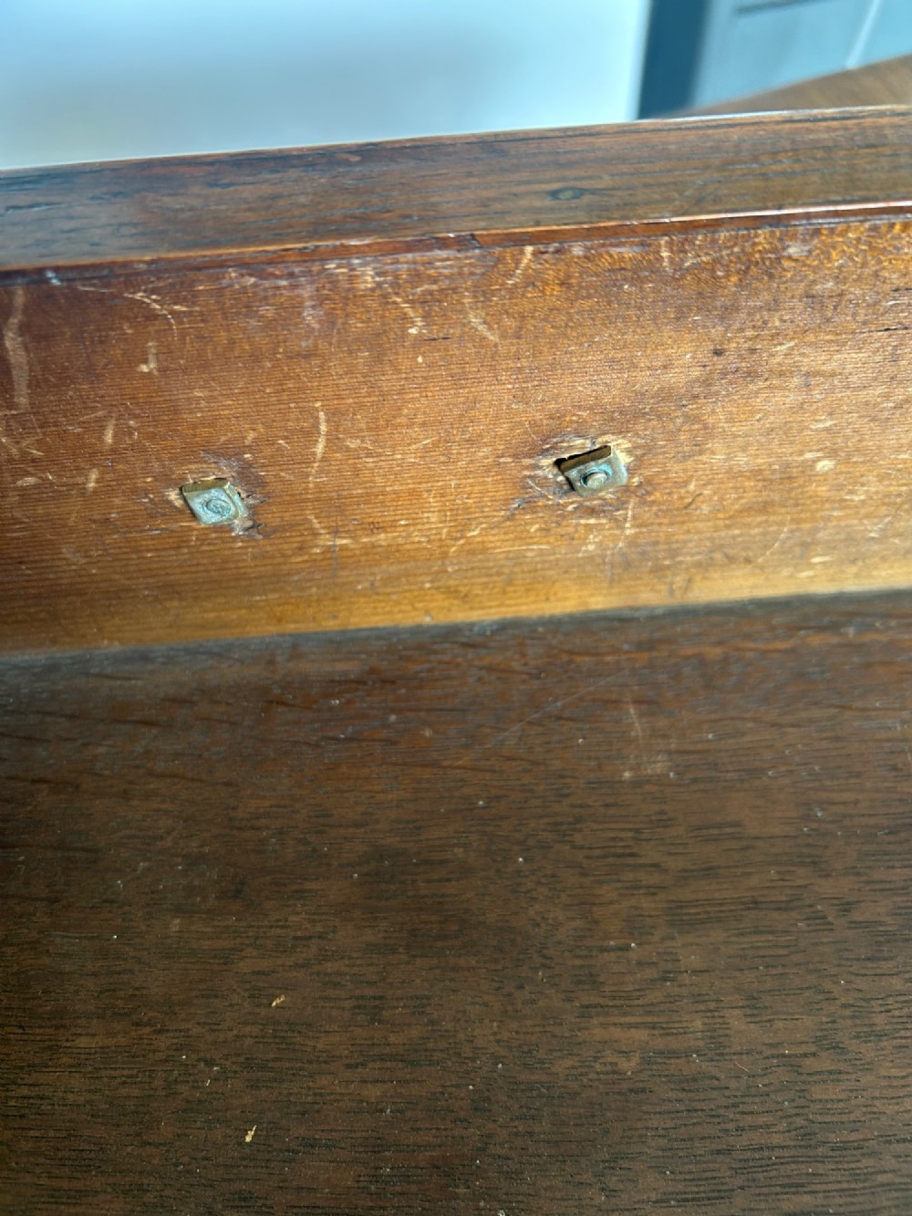 A George I walnut bachelors chest featuring four graduated drawers with feather-banded borders, brass bail handles, keyhole escutcheons, and shaped bracket feet. View IX
