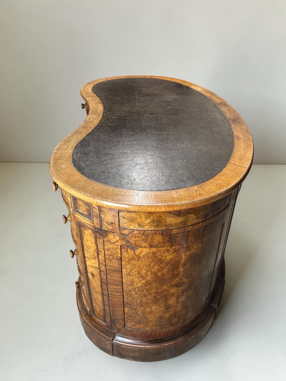A 19th-century freestanding kidney-shaped desk crafted from warm brown burr walnut with a dark leather inset top and dual drawer pedestals. View III