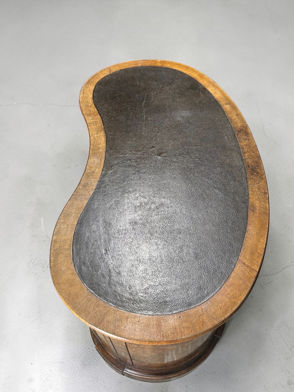A 19th-century freestanding kidney-shaped desk crafted from warm brown burr walnut with a dark leather inset top and dual drawer pedestals. View IV