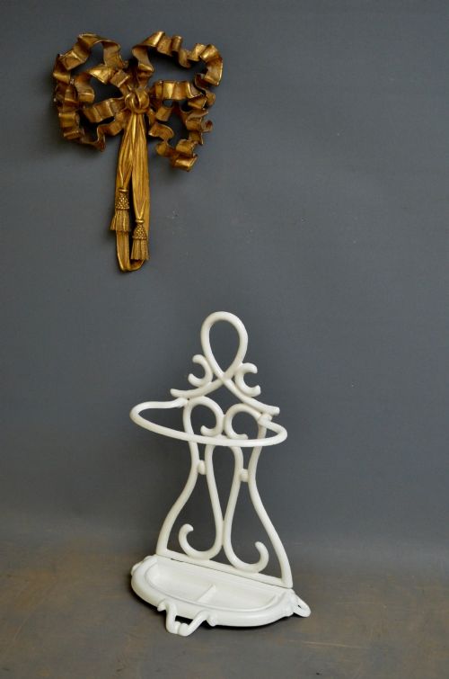 A white enamelled cast iron Art Nouveau umbrella stand featuring fluid scrollwork motifs and an integrated base drip tray. View V