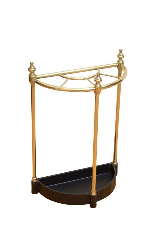 An Edwardian brass umbrella stand featuring a demi-lune frame, urn finials, three vertical posts, and a black cast iron drip tray with a dogtooth pattern. View III