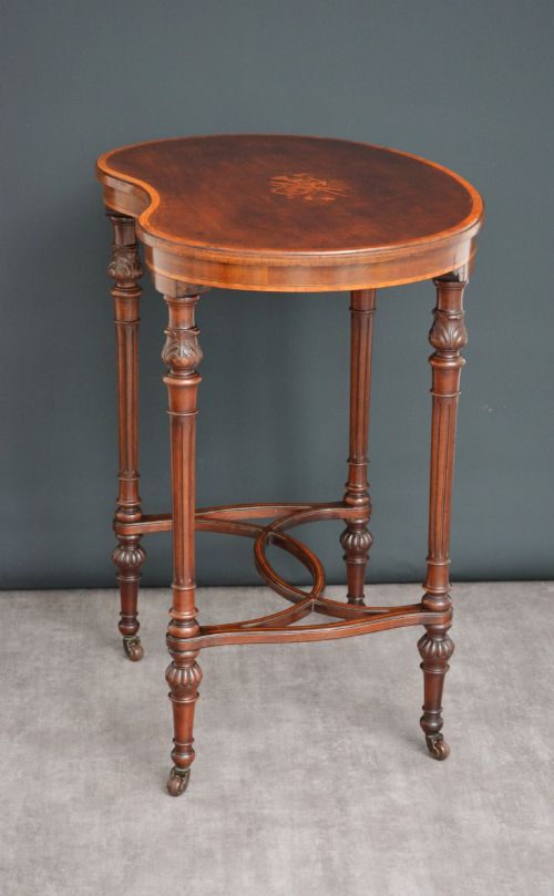 fig 1. An Edwardian mahogany kidney-shaped side table featuring inlaid marquetry at the centre, fluted turned legs, a curved stretcher, and small brass castors.
