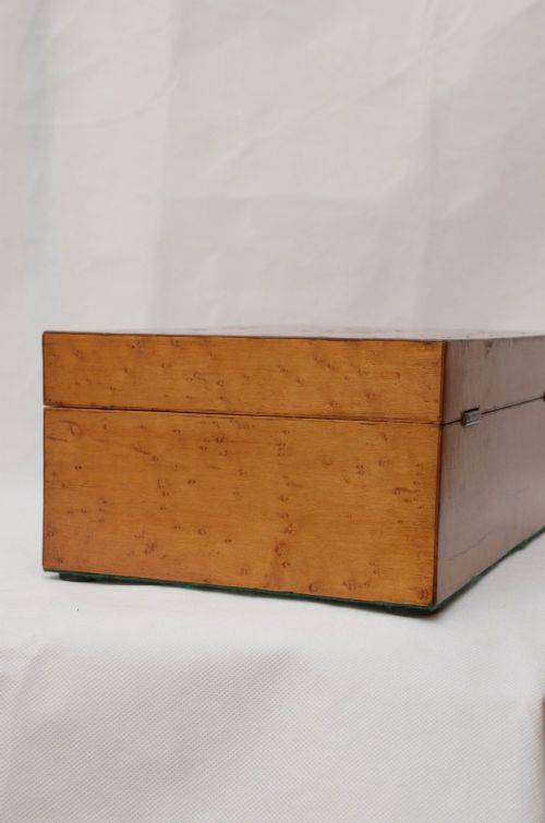 An open Victorian birds eye maple wooden box featuring scrollwork tulipwood inlay on the front and a green patterned paper interior lining. View VIII