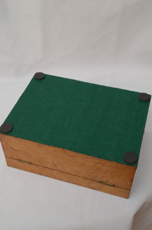 An open Victorian birds eye maple wooden box featuring scrollwork tulipwood inlay on the front and a green patterned paper interior lining. View XI
