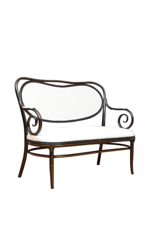 fig 3. An ebonised steam-bent wood settee with a cream upholstered backrest and seat cushion.