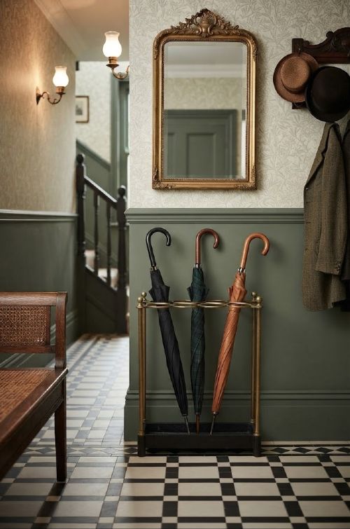 fig 1. A late nineteenth-century brass umbrella stand featuring eight circular divisions, four upright columns topped with ball finials, and a black cast iron drip tray base.