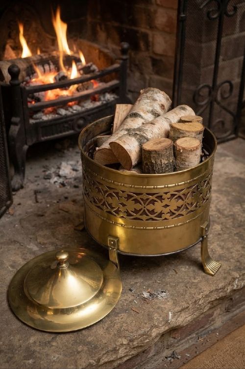 A cylindrical Edwardian polished brass coal bucket featuring a fretwork band, domed lid with finial, and three cast fluted feet. View III