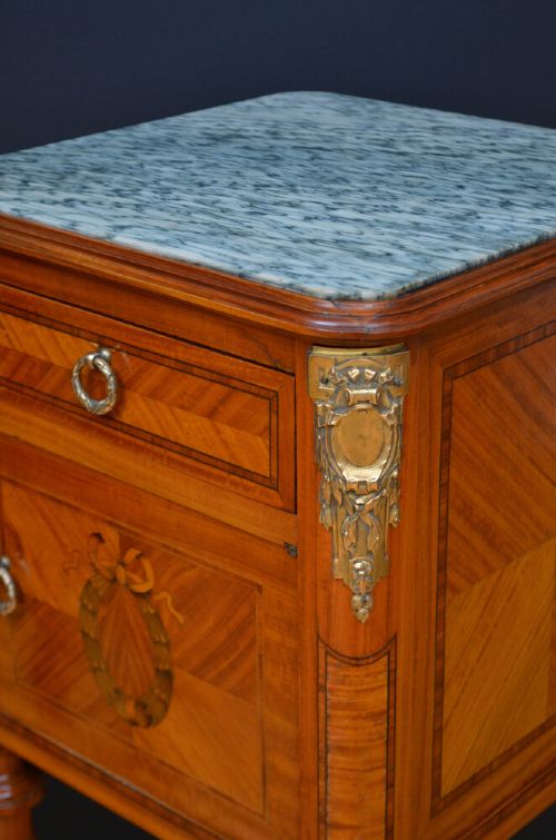 A pair of antique satinwood bedside cabinets with green marble tops, fluted turned legs, and decorative parquetry wood inlays. View IV
