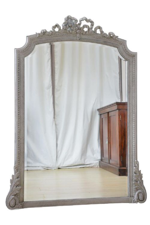 A light grey painted arched mirror featuring a carved ribbon bow crest and acanthus scroll corner details. View VIII
