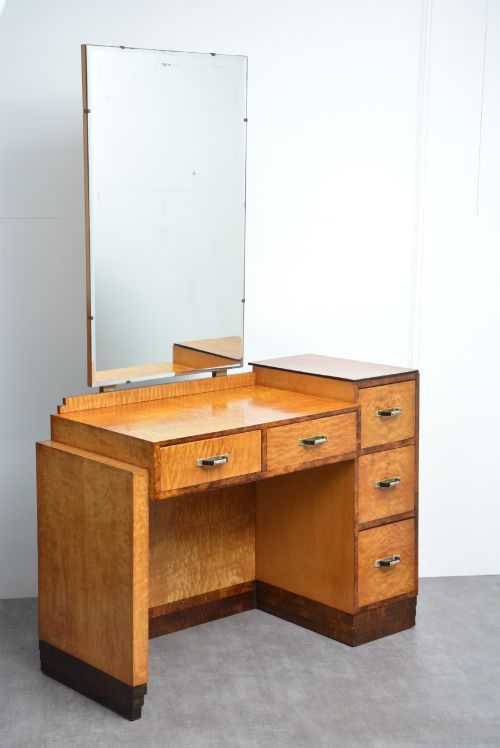 fig 1. An Art Deco asymmetrical dressing table crafted in burr maple veneer with an offset pedestal of drawers and a large frameless mirror.