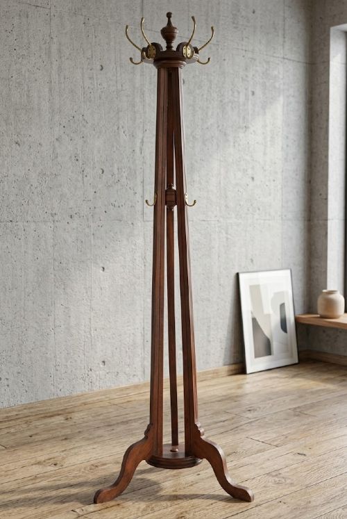 fig 1. A tall antique walnut coat stand featuring a revolving top section with six brass hooks, a tapered central column, and four splayed feet.