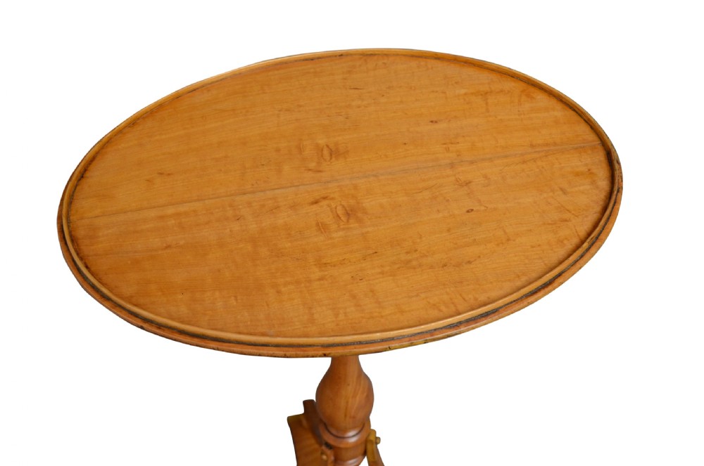 A light wood satinwood occasional table featuring an oval top, a turned central pedestal, and a tripod base with bun feet. View II