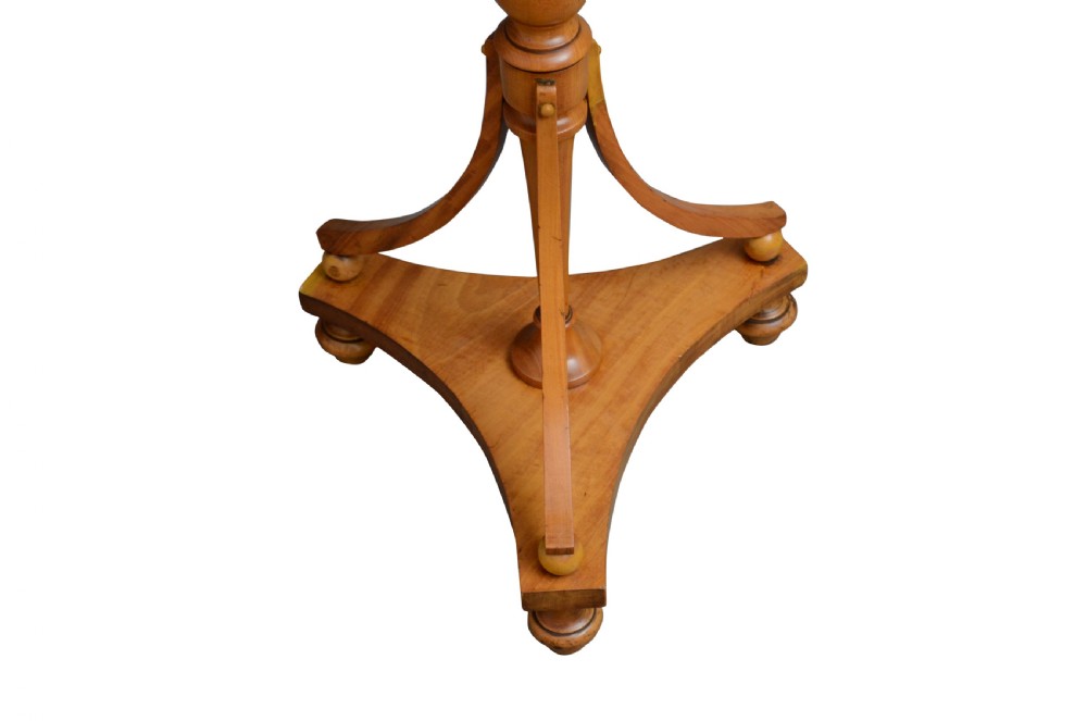 A light wood satinwood occasional table featuring an oval top, a turned central pedestal, and a tripod base with bun feet. View V
