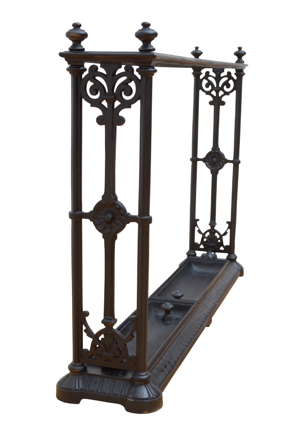 An ornate black cast iron umbrella and walking stick stand featuring openwork scroll panels, vertical pillars, and a compartmentalised base drip tray.